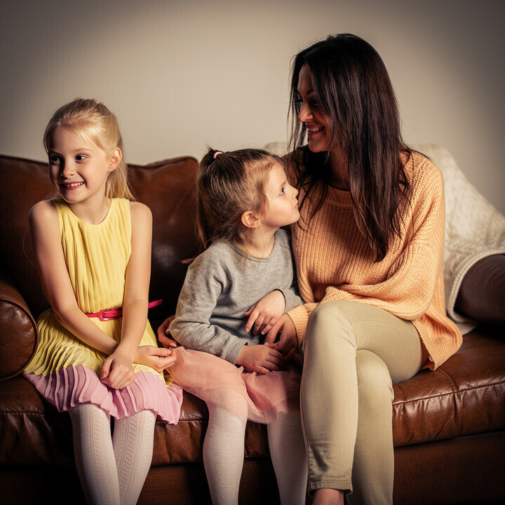 Photorealistic portrait made from mom with kids on the couch